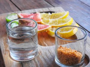 mezcal shot served with sliced fruit