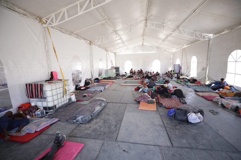 migrantes en campamento del puente