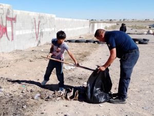 polis y jovenbes limpian baldio